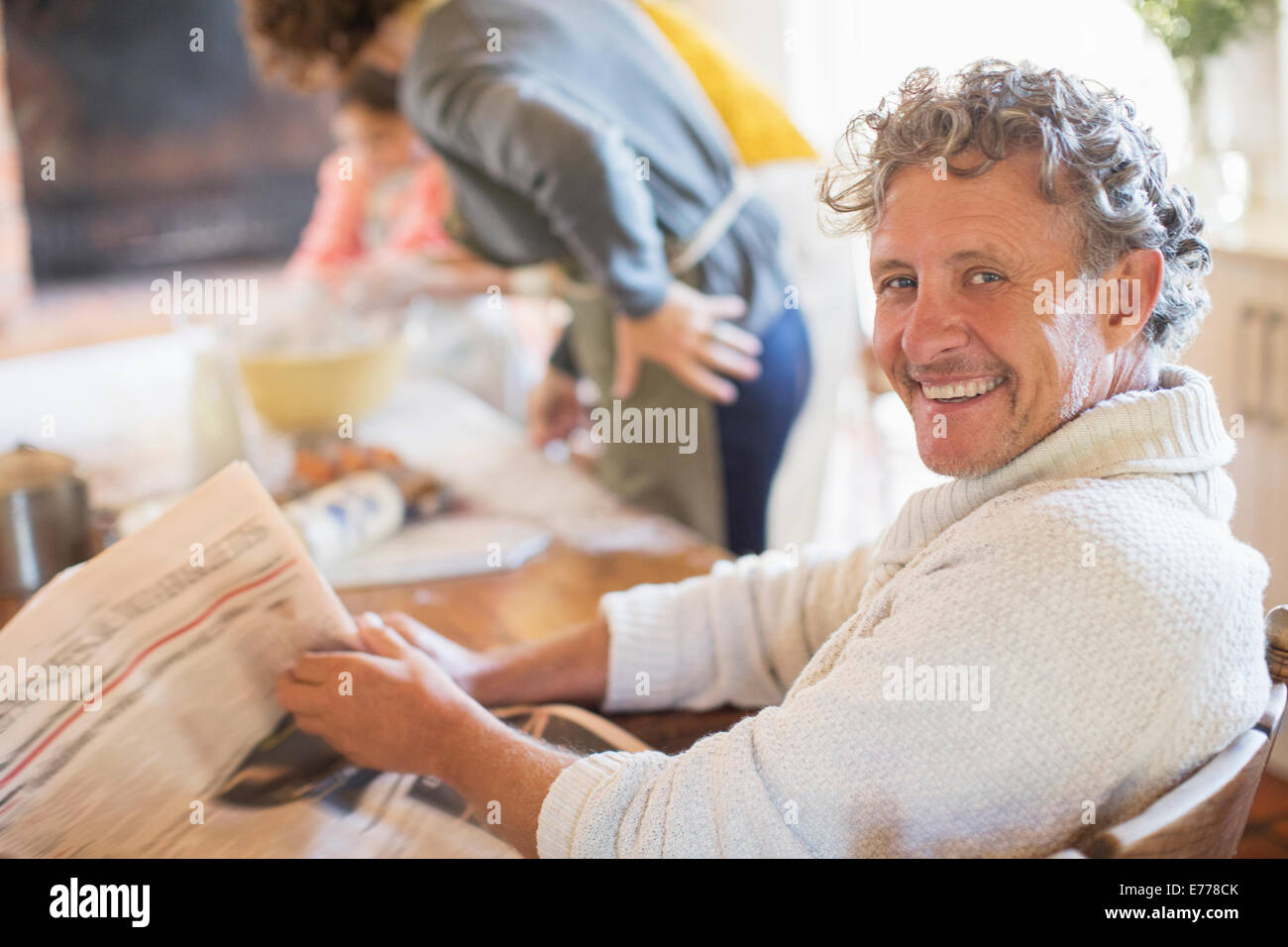 Ältere Mann liest Zeitung in Küche Stockfoto
