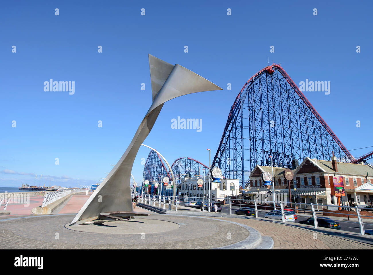 Whale Tail Skulptur auf der Promenade in Blackpool mit dem "Big One"-Achterbahn hinter Stockfoto