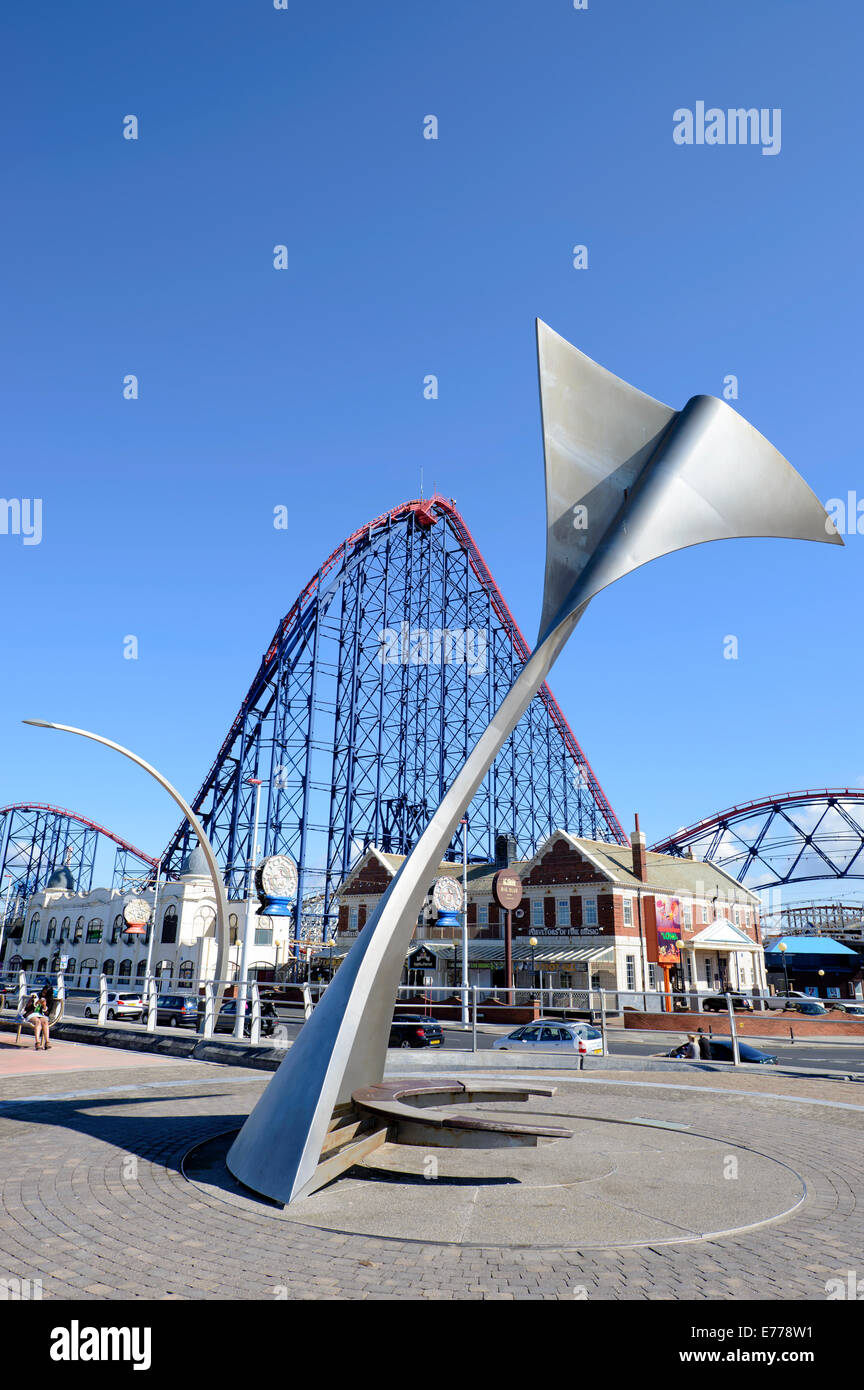 Whale Tail Skulptur auf der Promenade in Blackpool mit dem "Big One"-Achterbahn hinter Stockfoto