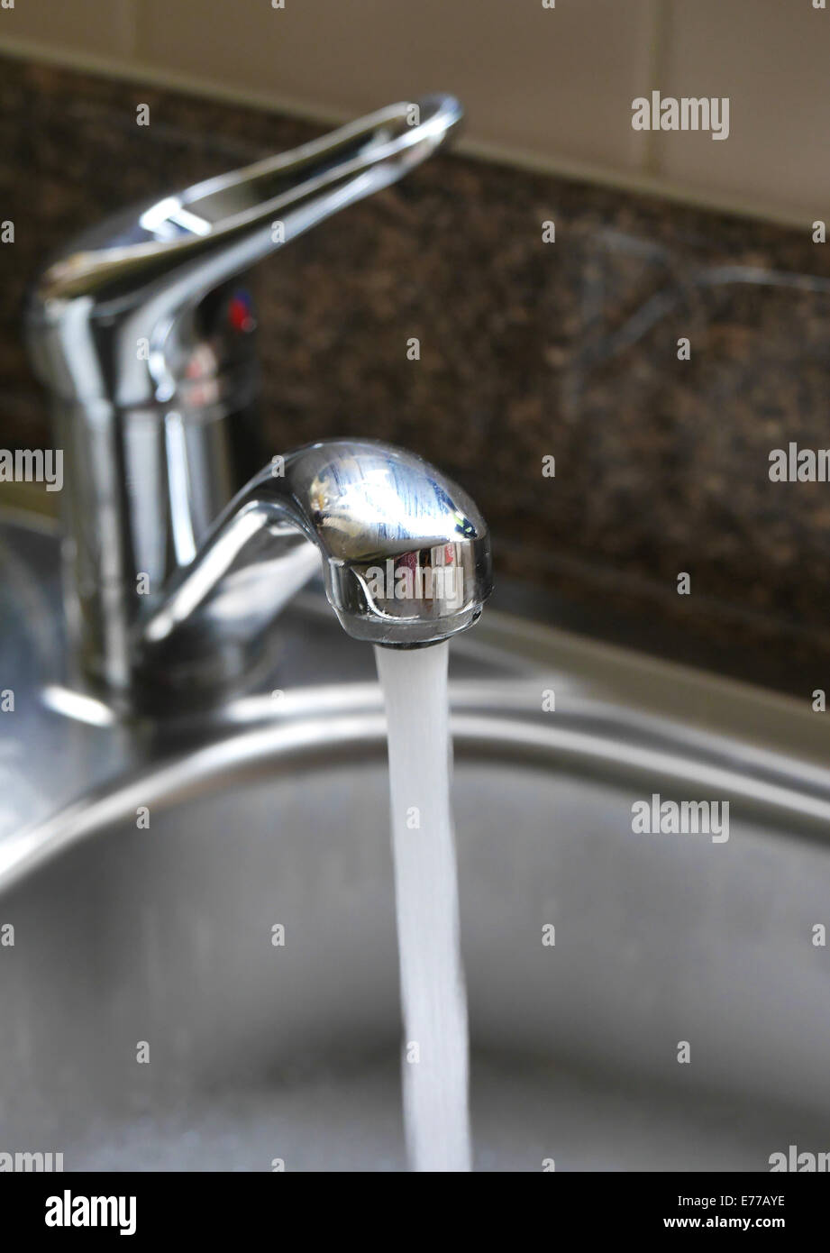 Wasser fließt aus dem Hahn im Spülbecken Stockfoto
