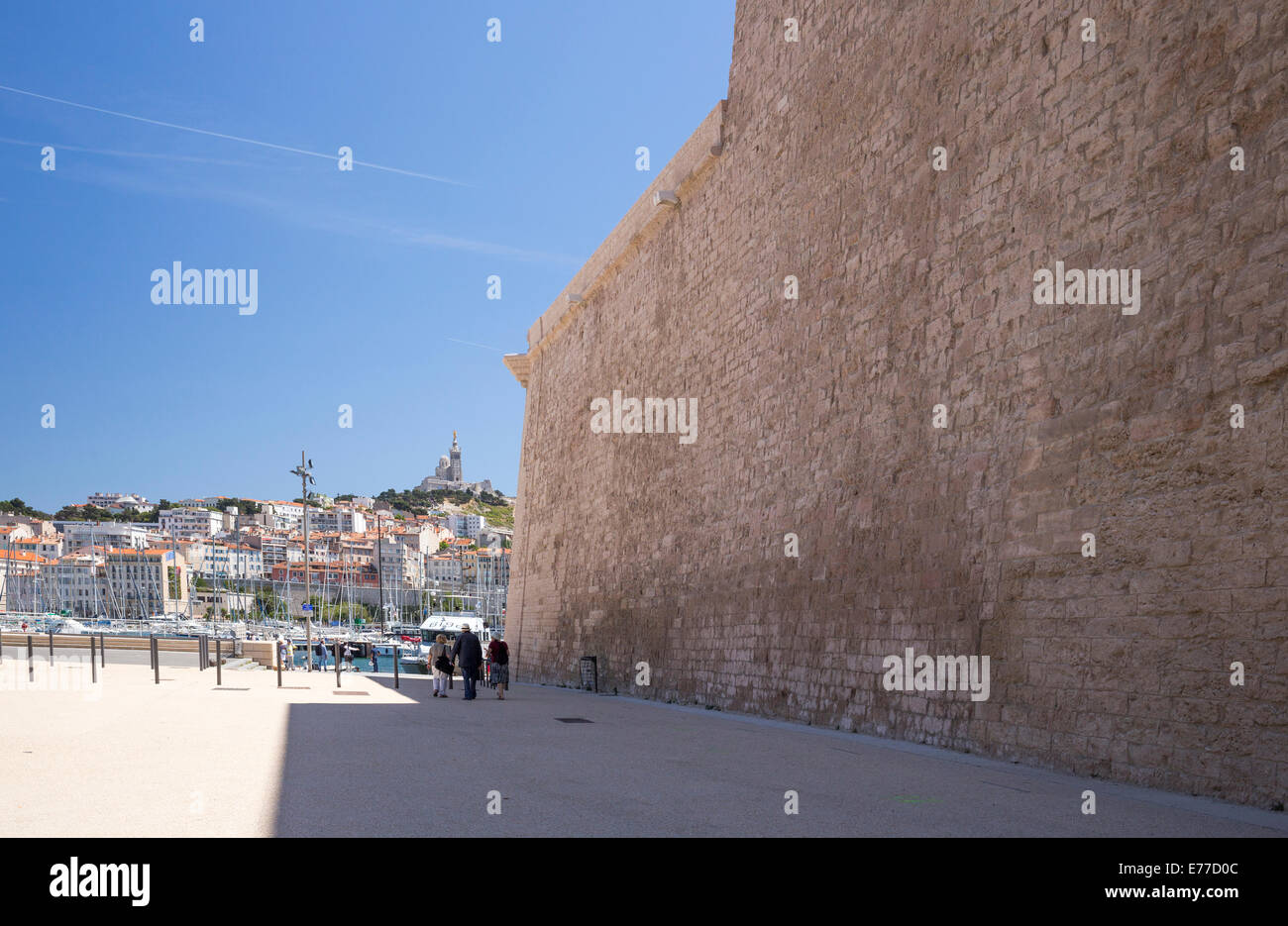 Massive Wand von Fort St. Jean in Marseille Frankreich und Basilika auf Hügel in Ferne Stockfoto