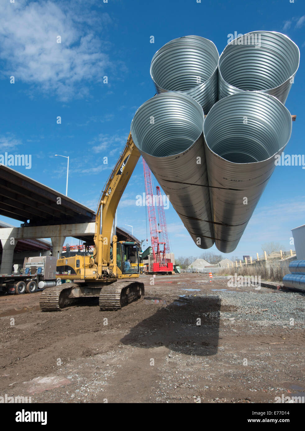 Baggerlader verschiebt riesige Metall Leerrohre für New Haven Hafen Crossing Projekt. Stockfoto