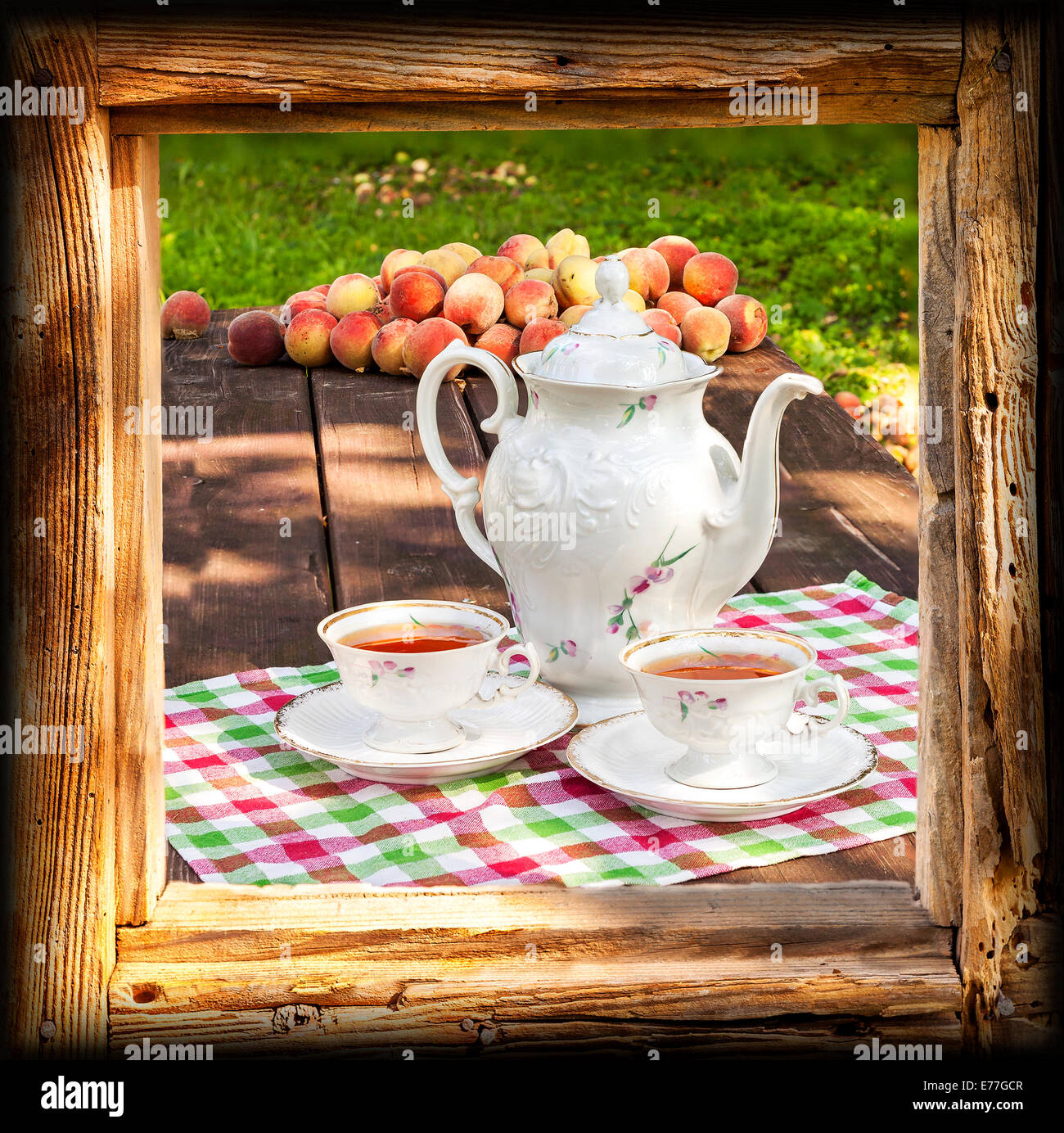 Tee-Set im Garten in Holzrahmen. Stockfoto
