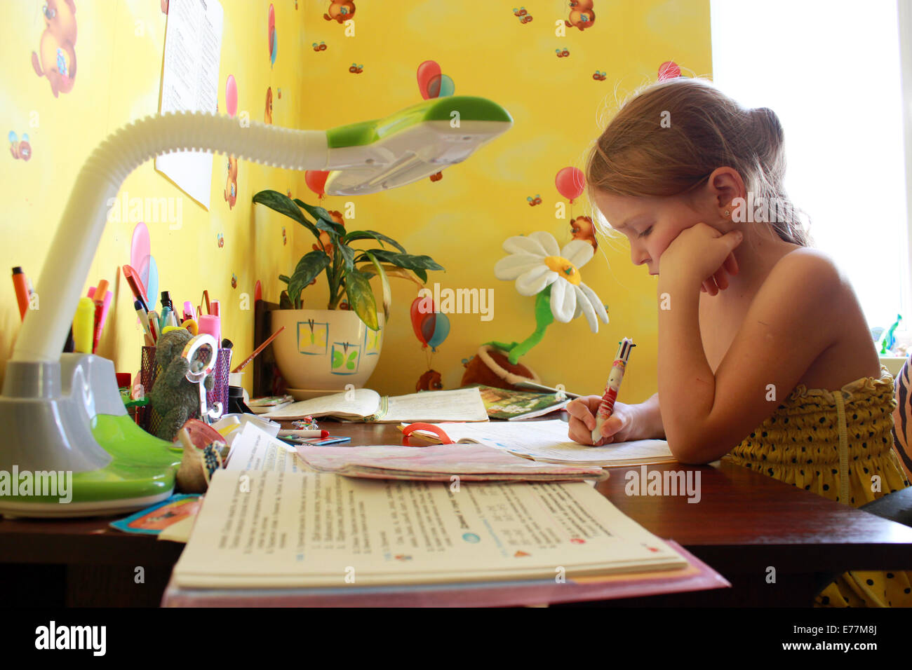 Schulmädchen lernt Lektionen am Tisch in ihrem Zimmer Stockfoto