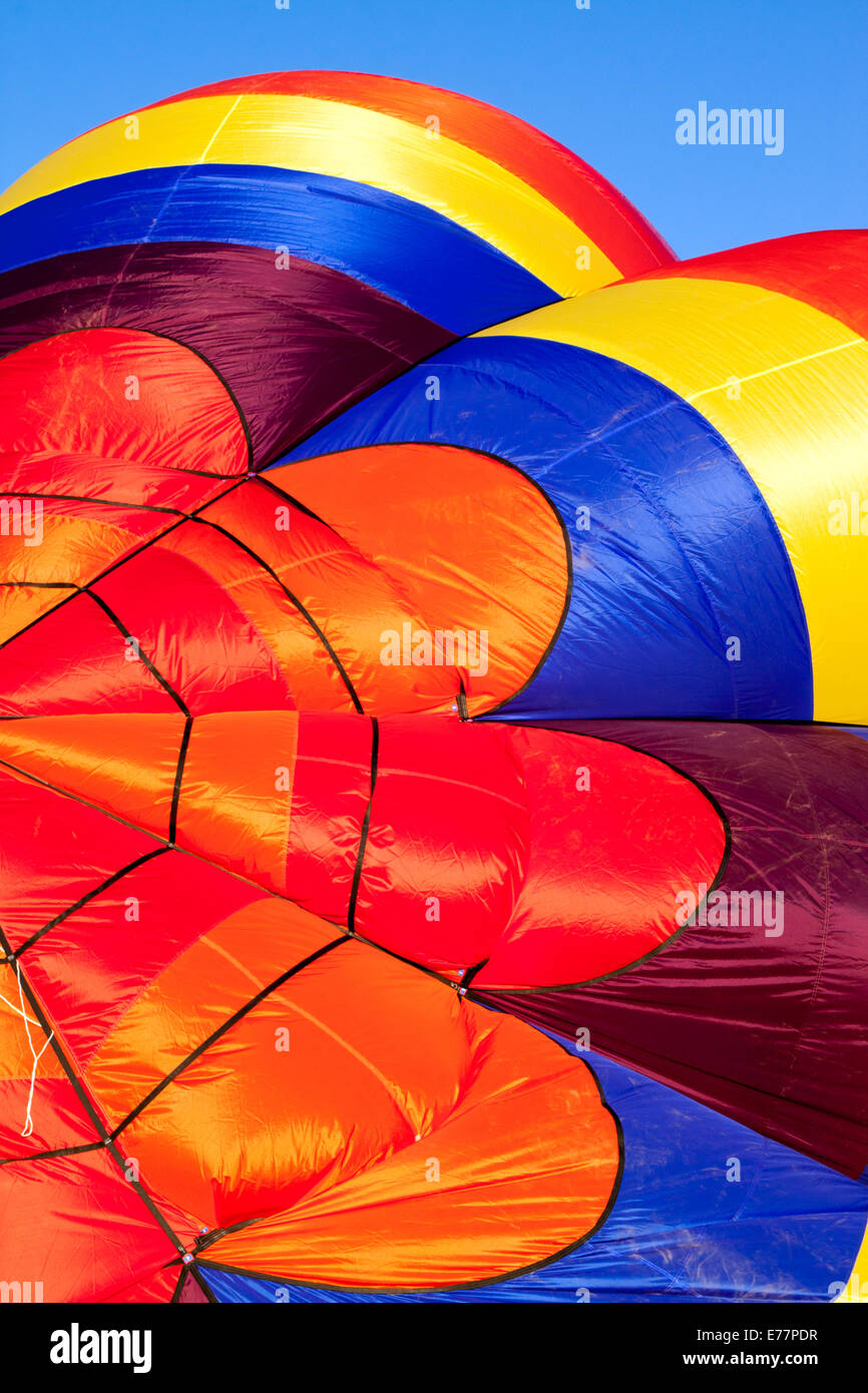 Detail eines Heißluft-Ballon wird aufgeblasen im frühen Morgenlicht vor blauem Himmel Stockfoto