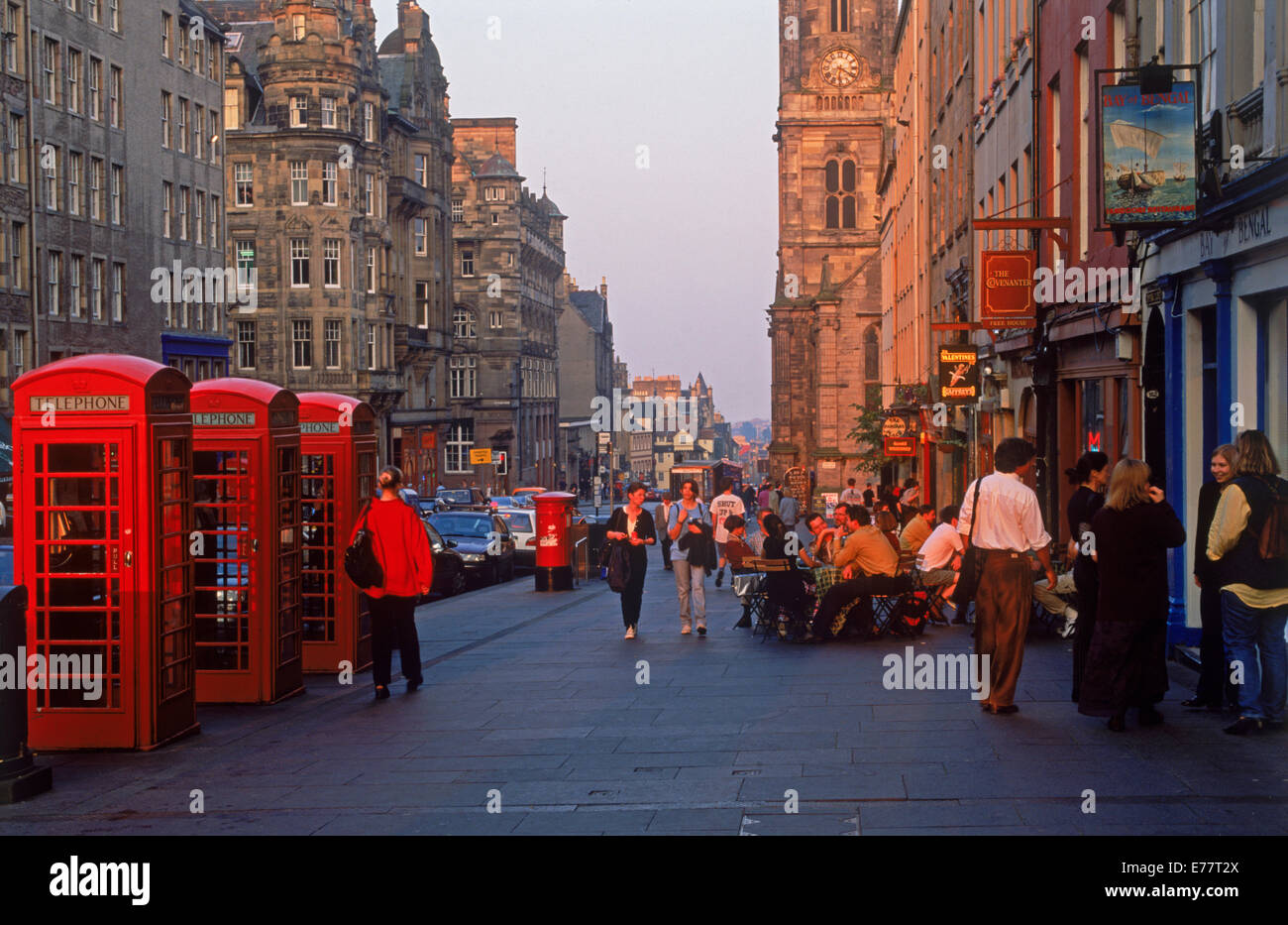 Telefonzellen, Fußgänger und Pubs entlang der Royal Mile in Edinburgh im Abendlicht Stockfoto