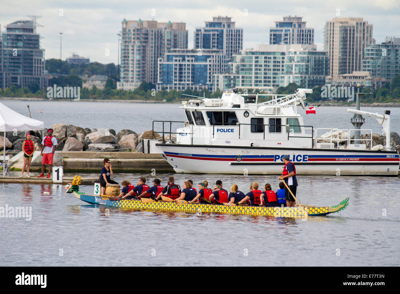 Toronto Police Dragon Boat Team geht mit dem Toronto Polizei Marine Boot Weg zum Start ihrer Rasse. Stockfoto