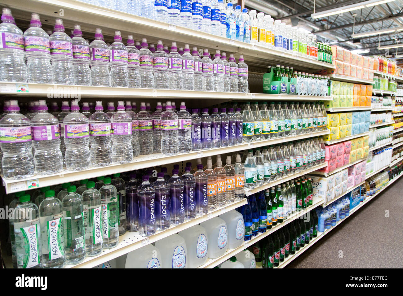 Eine natürliche Lebensmittel Lebensmittelgeschäft Gang mit Regalen von Wasser in Flaschen. Stockfoto