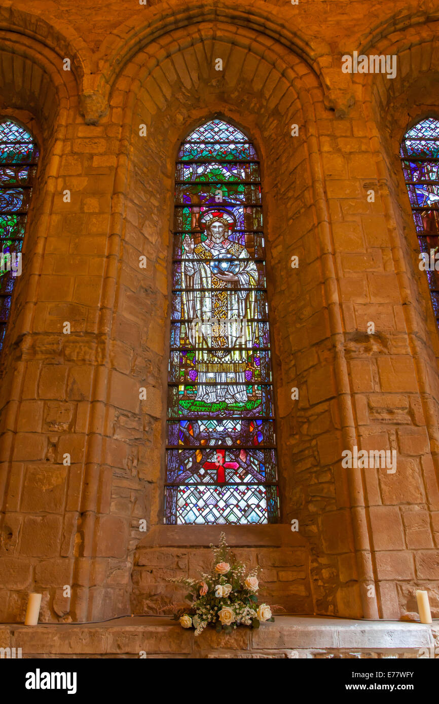 Großes Fenster in einer kleinen schottischen Kathedrale, gelbe Lichter Stockfoto