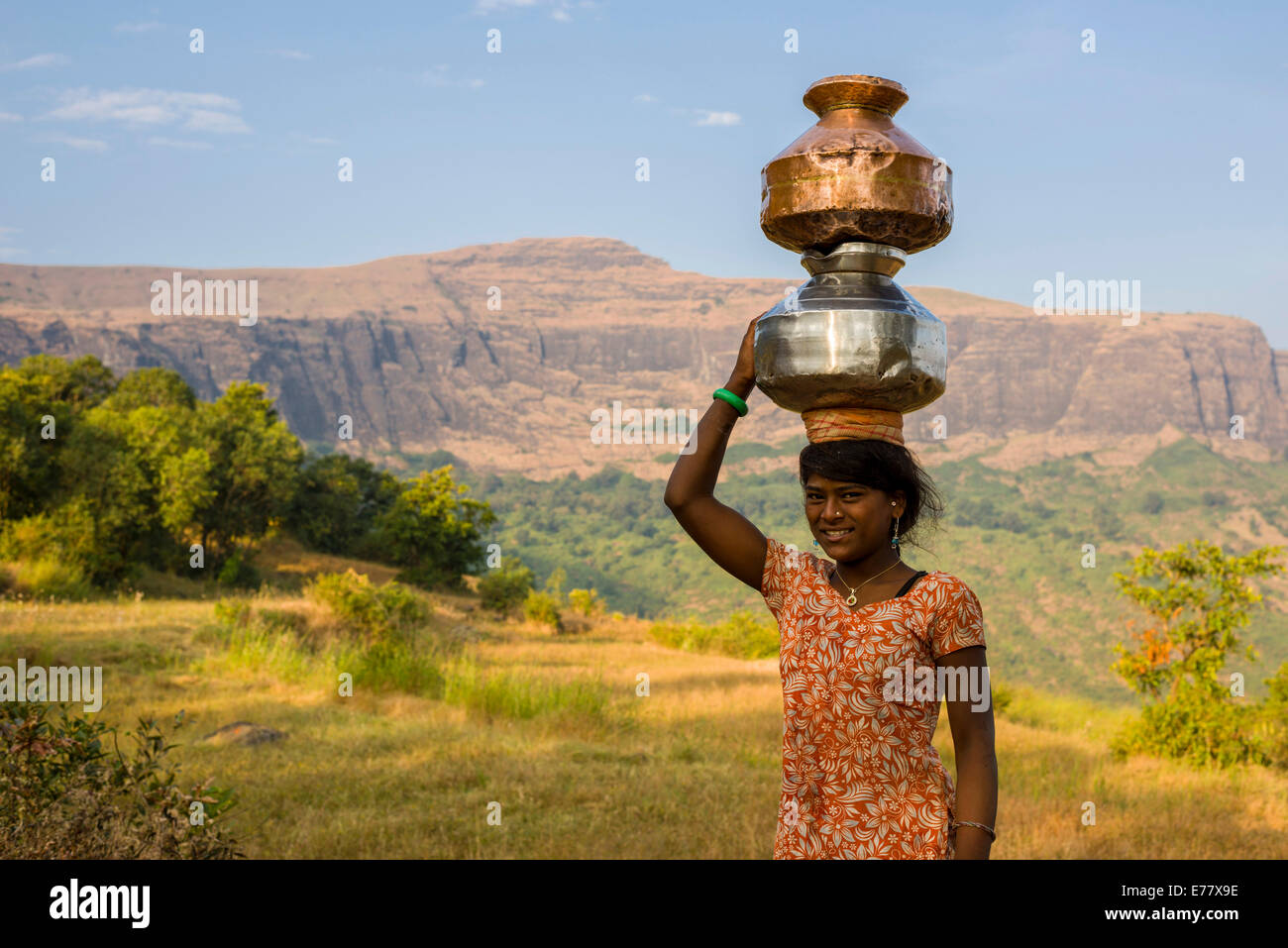 Ein Mädchen trägt zwei Töpfe gefüllt mit Wasser auf dem Kopf, Trimbak, Maharashtra, Indien Stockfoto