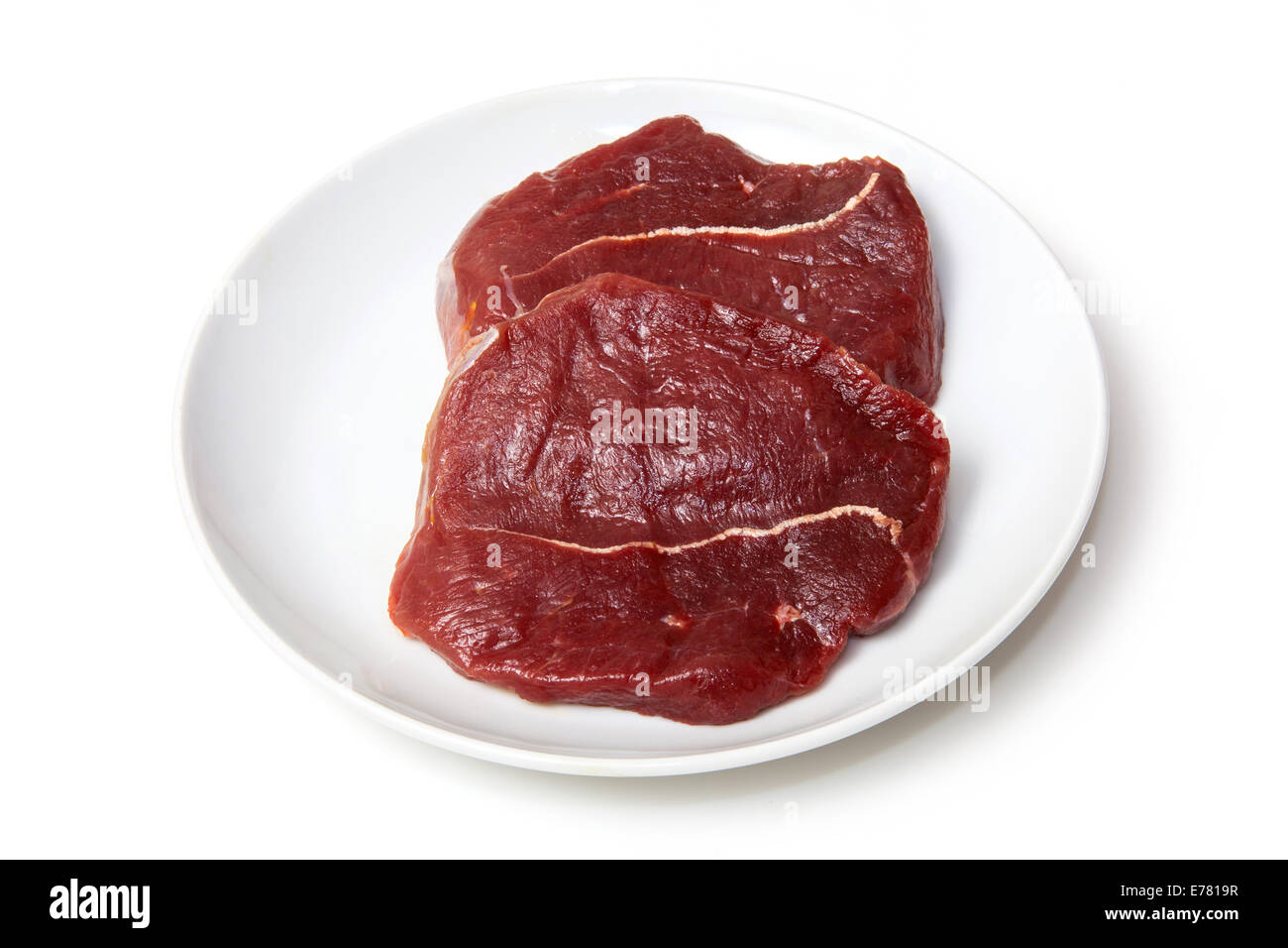 Teller mit rohem Zebra Steaks isoliert auf einem weißen Studio-Hintergrund Stockfoto