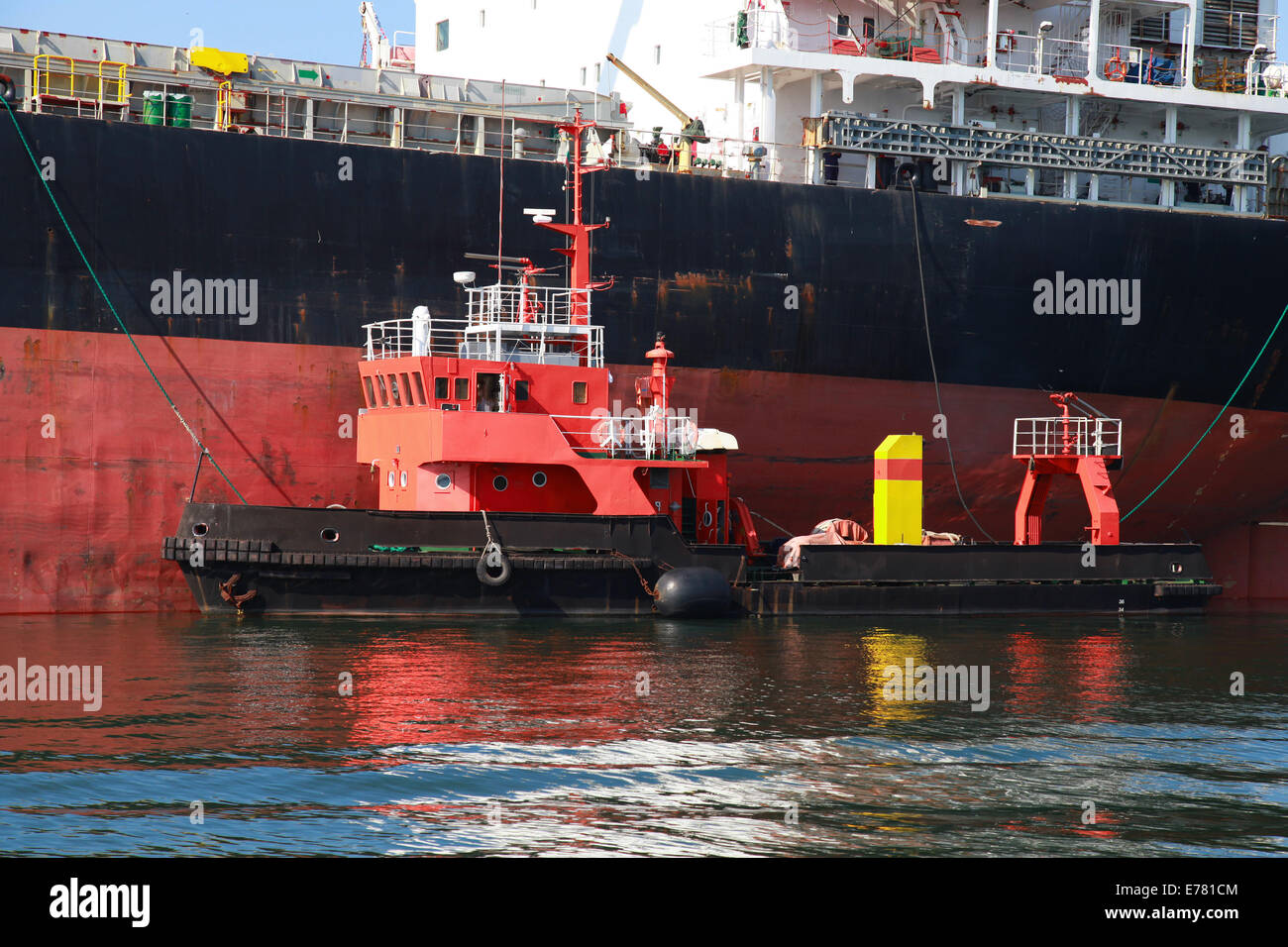 Roten Unterstützung Schlepper und große Ladung Schiff. Hafen von Burgas, Bulgarien Stockfoto