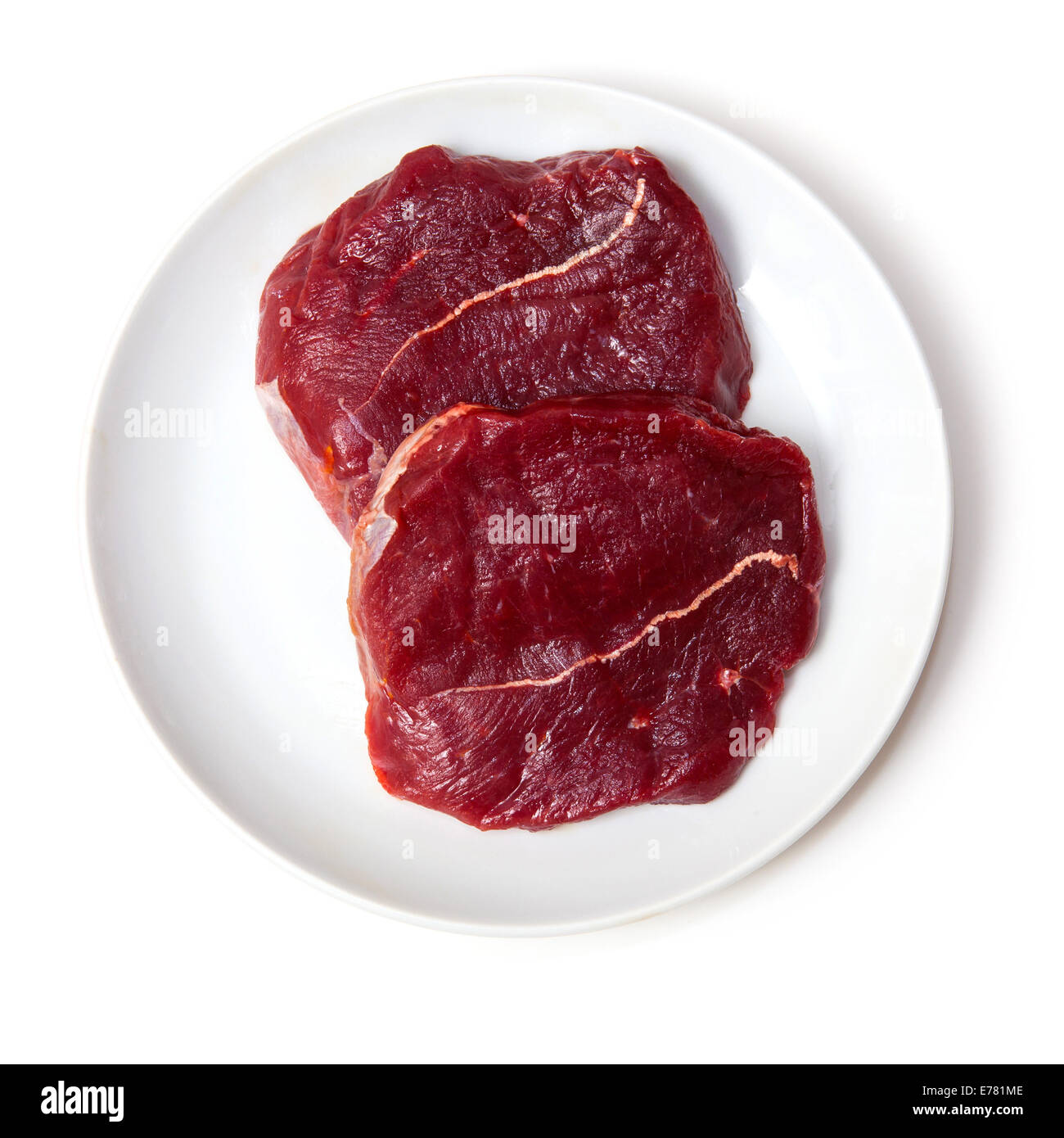 Teller mit rohem Zebra Steaks isoliert auf einem weißen Studio-Hintergrund Stockfoto