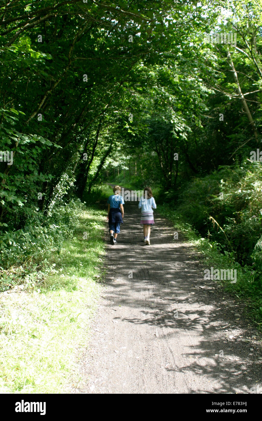 Ein Junge und ein Mädchen zusammen durch den Wald spazieren. Stockfoto