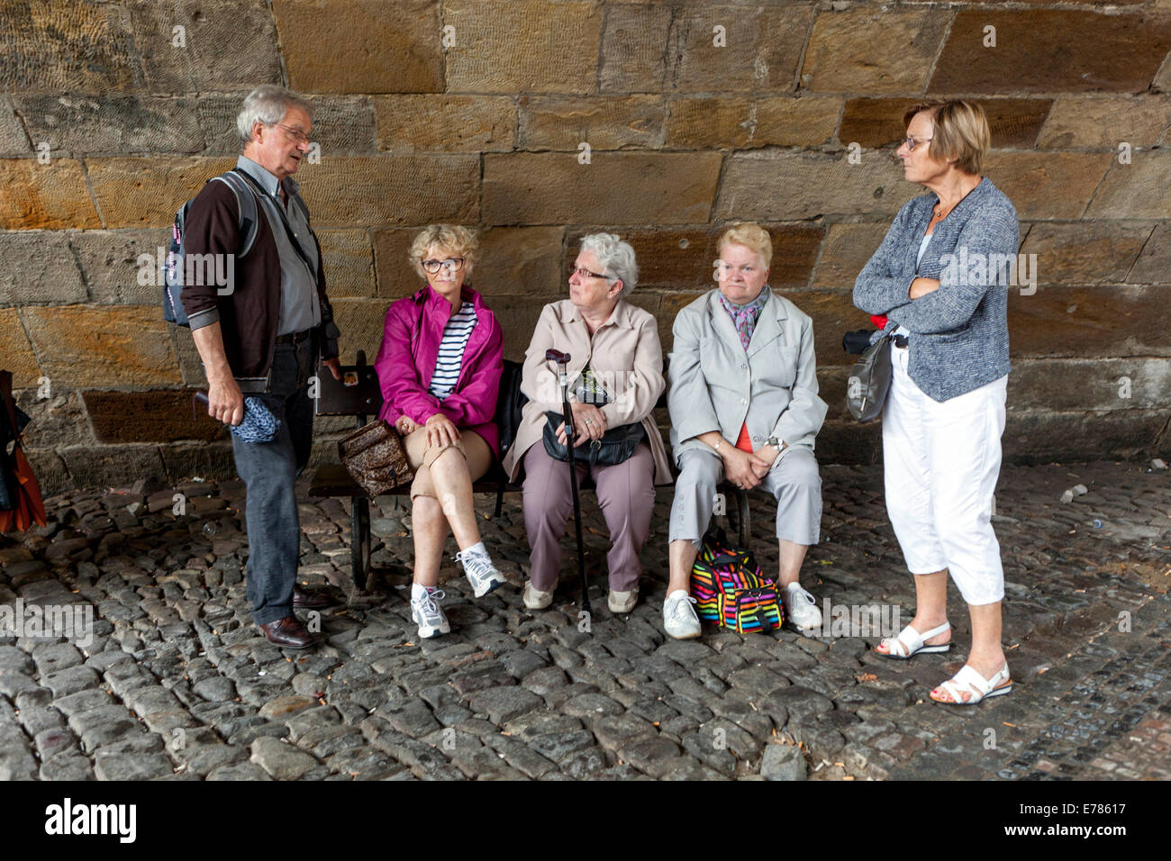 Müde, ältere Leute, Touristen, Entspannung, Rentner auf der Bank unten Karlsbrücke, Prag, Tschechische Republik Stockfoto