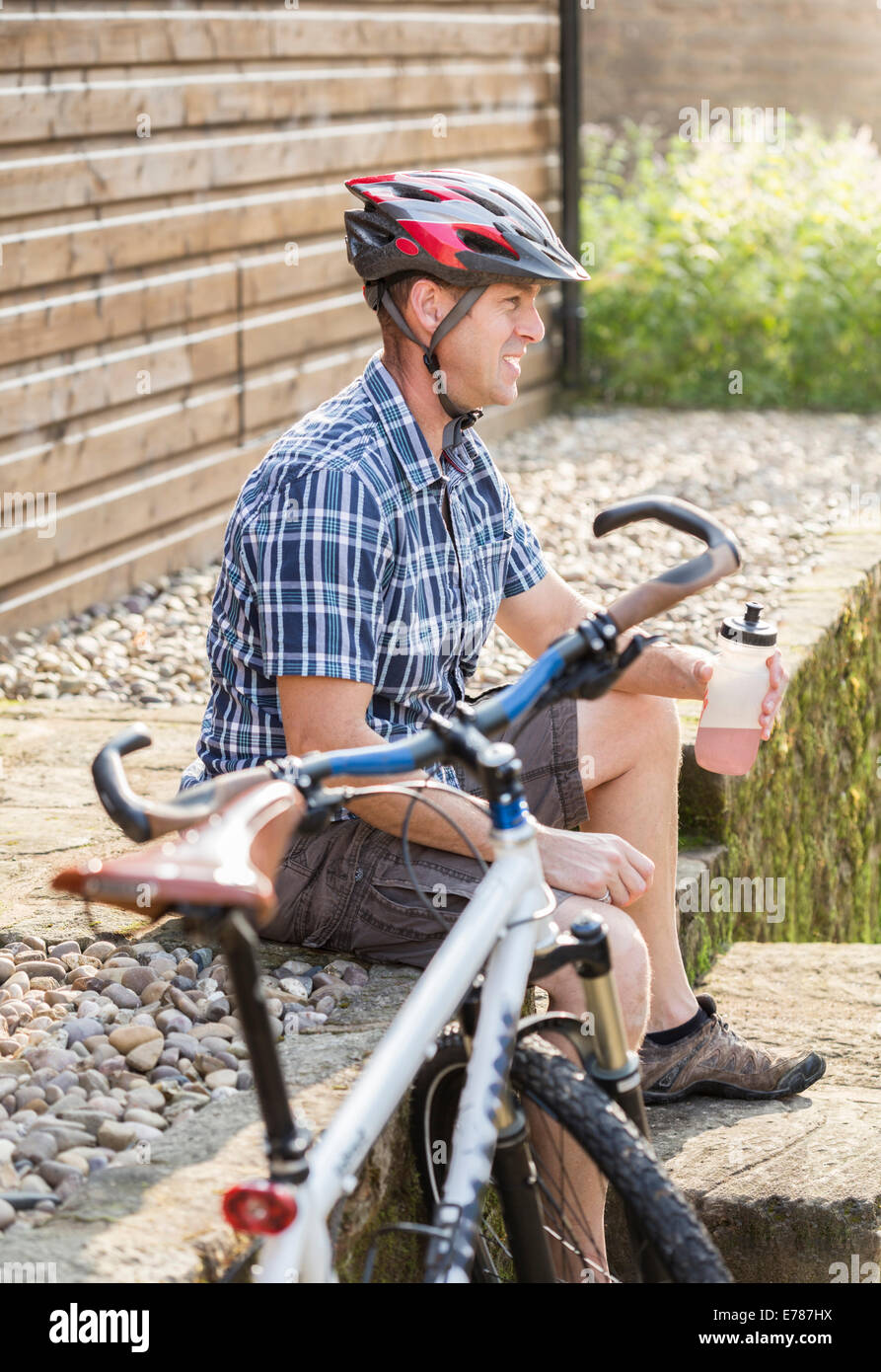 Radfahrer mit einem Energy-Drink entspannen. Stockfoto