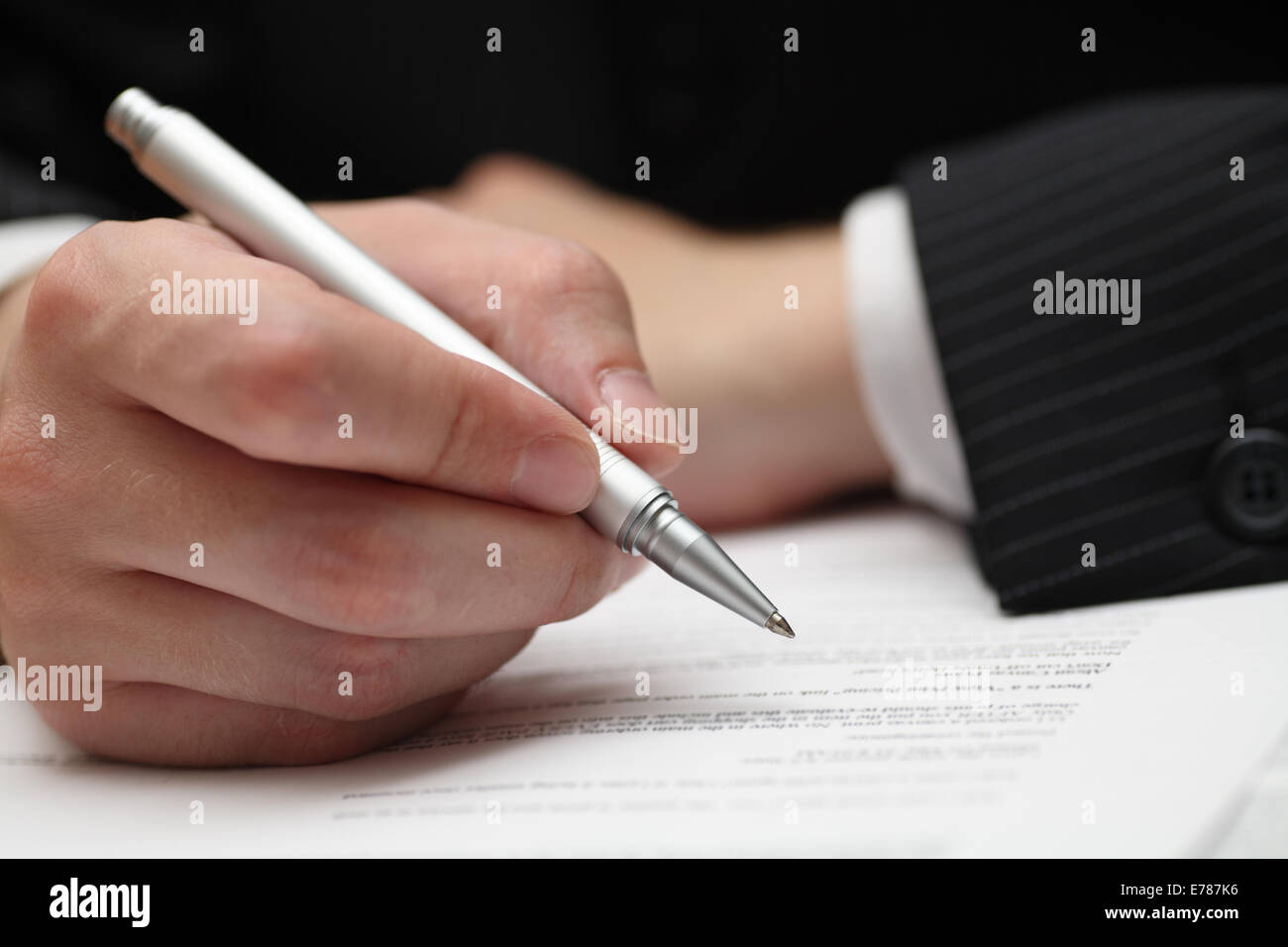 Geschäftsmann, betrachten den Vertrag vor der Unterzeichnung. Close-up. Pen im Mittelpunkt. Geringe Schärfentiefe. Stockfoto