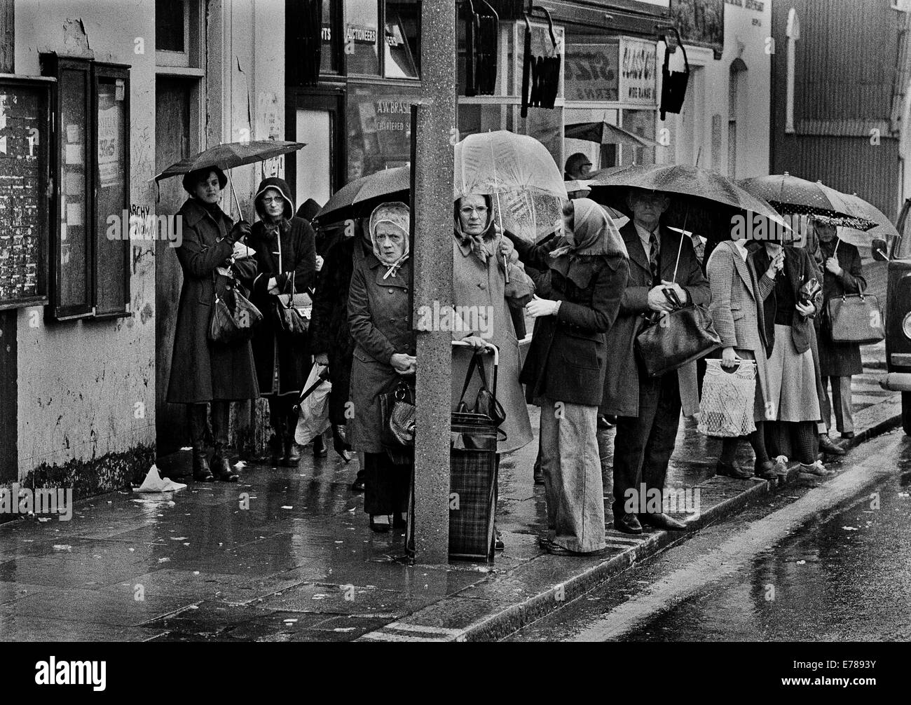 Die Warteschlange warten auf Bus in London, North Kensington im Regen. Stockfoto