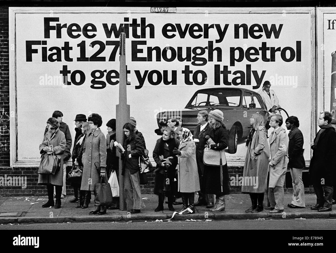 Die Warteschlange warten auf Bus in North Kensington vor Fiat-Werbeplakat. Fiat 127 war eines der ersten modernen s Stockfoto