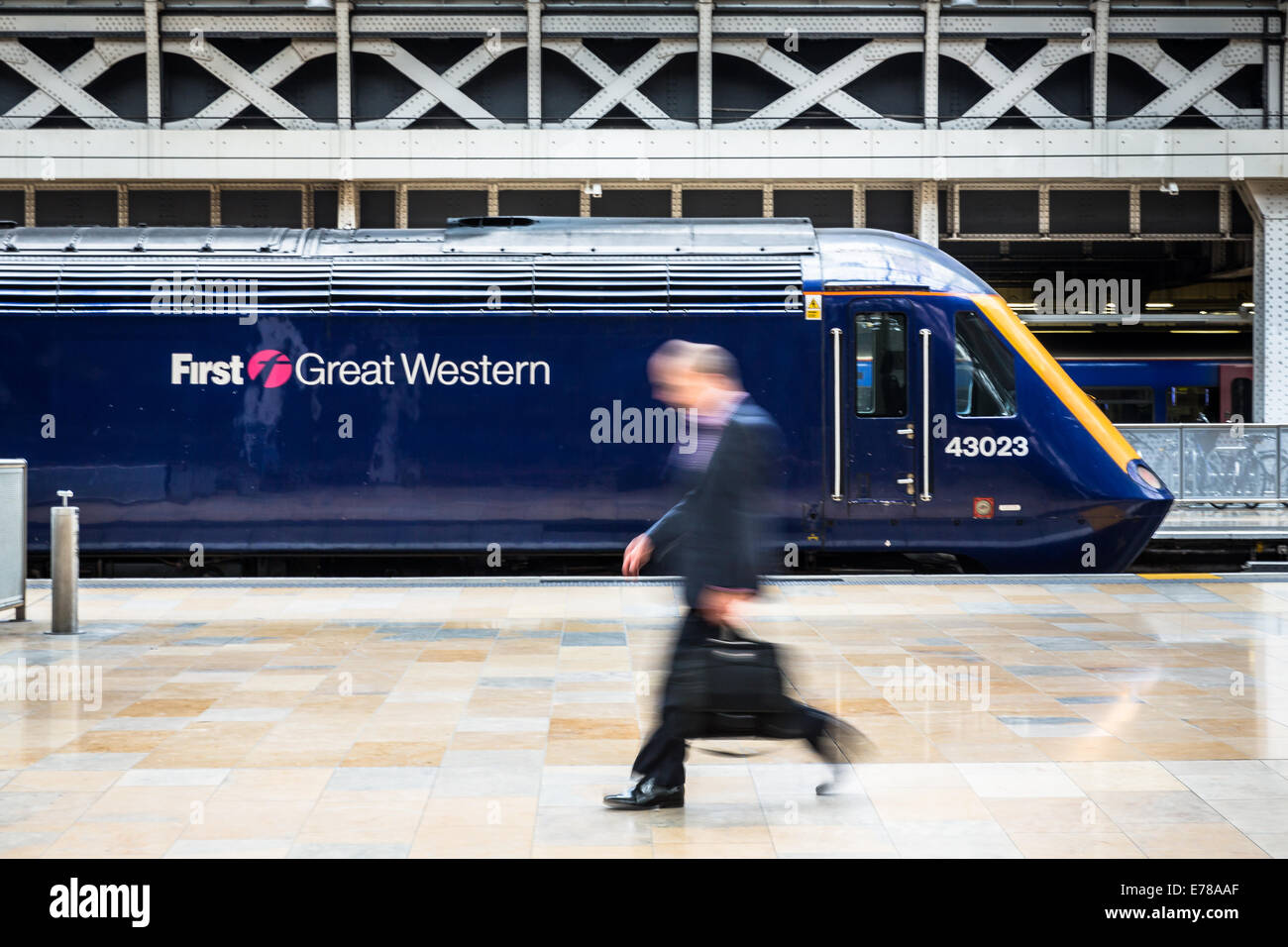 Ein Geschäft Pendler Spaziergänge übergeben einen stationären erstes Great Western Intercity Zug am Bahnhof Paddington in London, England, UK Stockfoto