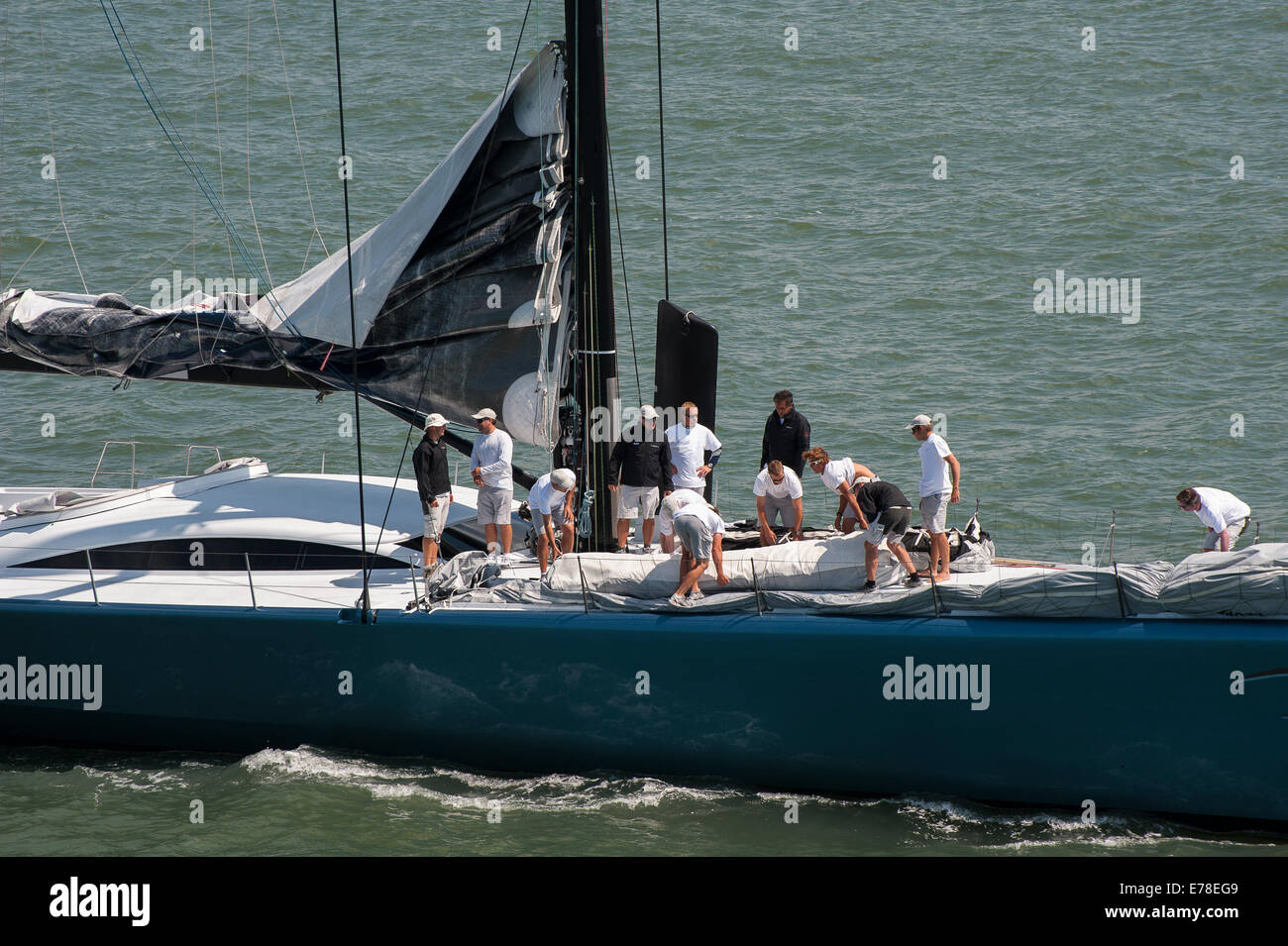 Mannschaft arbeitet auf dem Deck einer Luxusyacht Segeln vor der Küste von Southampton, England. Stockfoto