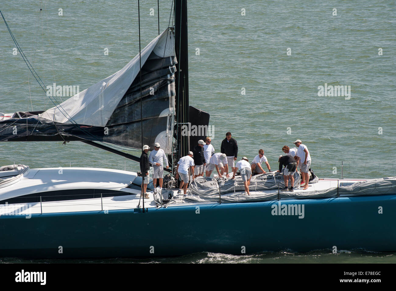 Mannschaft arbeitet auf dem Deck einer Luxusyacht Segeln vor der Küste von Southampton, England. Stockfoto