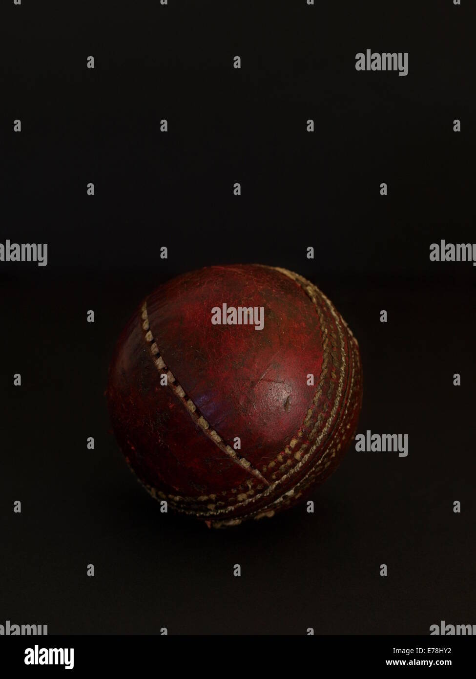 Cricketball auf schwarzem Hintergrund Stockfoto