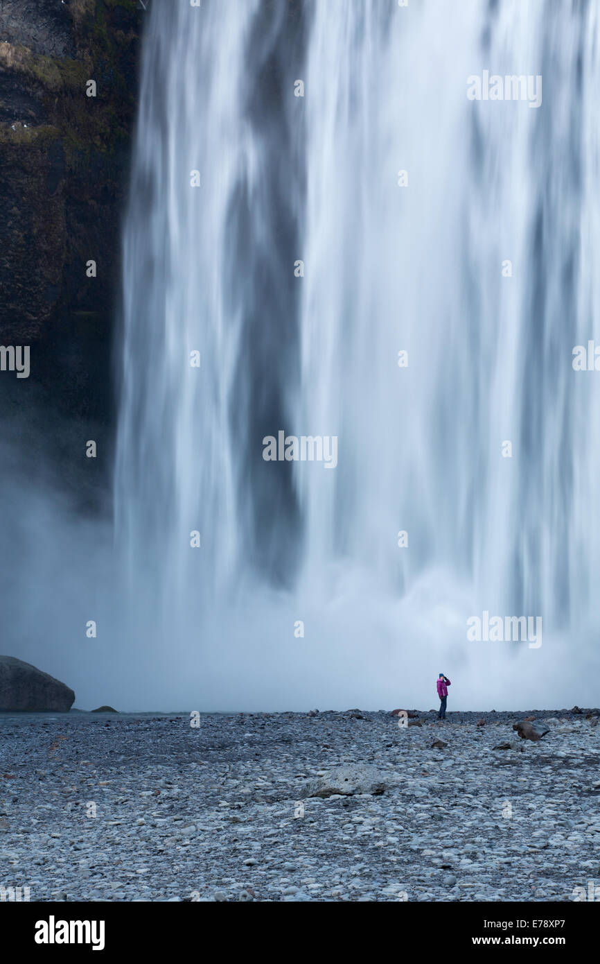 der einsame Figur von Wendy Stand am Fuße des Skógafoss, Süden Islands Stockfoto