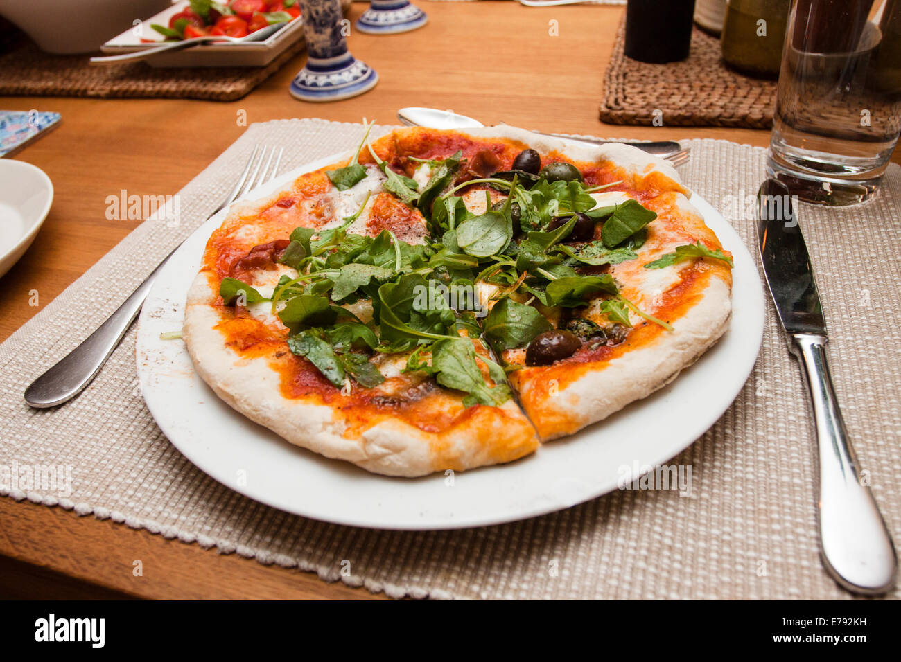 Hausgemachte Pizza mit Natursauerteig Kruste und Rucola Blätter an der Spitze Stockfoto