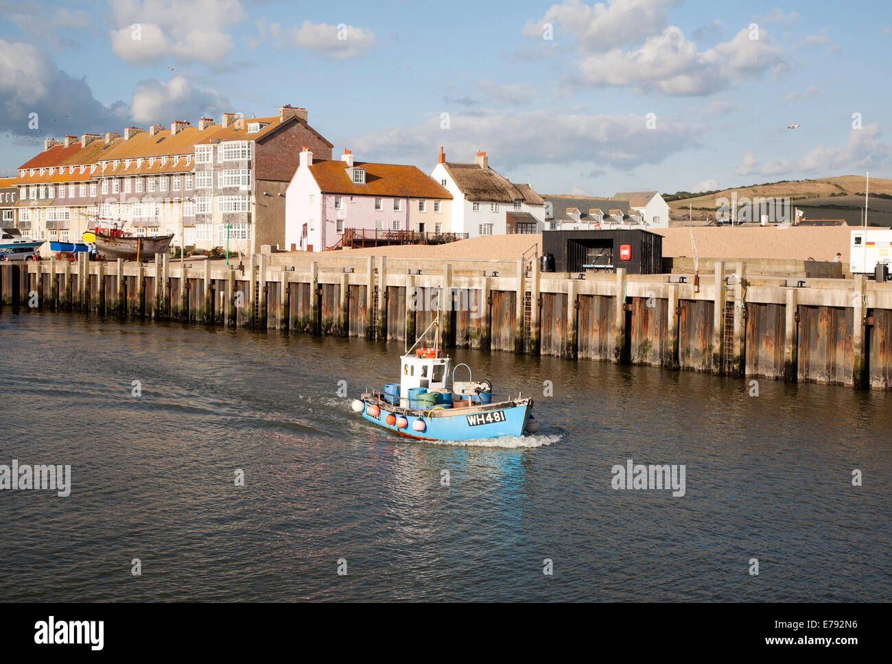 Kleines Fischerboot verlassen den Hafen von West Bay, Bridport, Dorset, England Stockfoto
