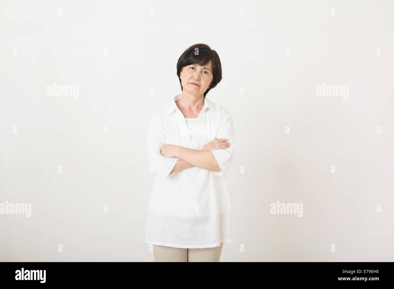 Ältere Erwachsene Japanerin gegen weiße Wand Stockfoto