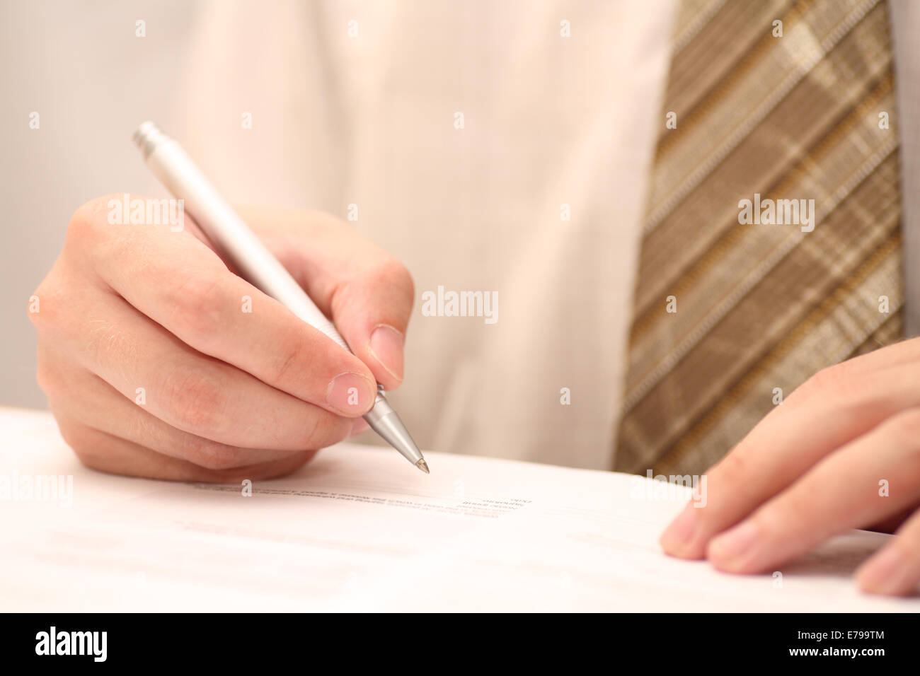 Geschäftsmann, betrachten den Vertrag vor der Unterzeichnung. Close-up. Konzentrieren Sie sich auf Seite und Stift. Geringe Schärfentiefe. Stockfoto
