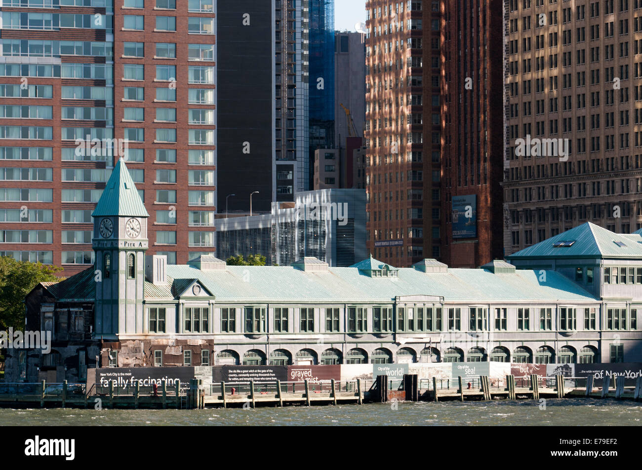 Riesigen Wolkenkratzern Uferpromenade vom Battery Park und Pier A. Pier A im Battery Park ist ein Gebäude, erbaut 1886 durch die Abteilung des Docks und Fähren, teilweise renoviert noch einen trauriger Zustand präsentiert, es scheint, dass es ein Streit zwischen den Behörden und die Unternehmen hinter seiner Rehabilitation. Im vergangenen Frühjahr begrüßt Amelia Earhart, die Königin und verschiedene Staatsoberhäupter. Stockfoto