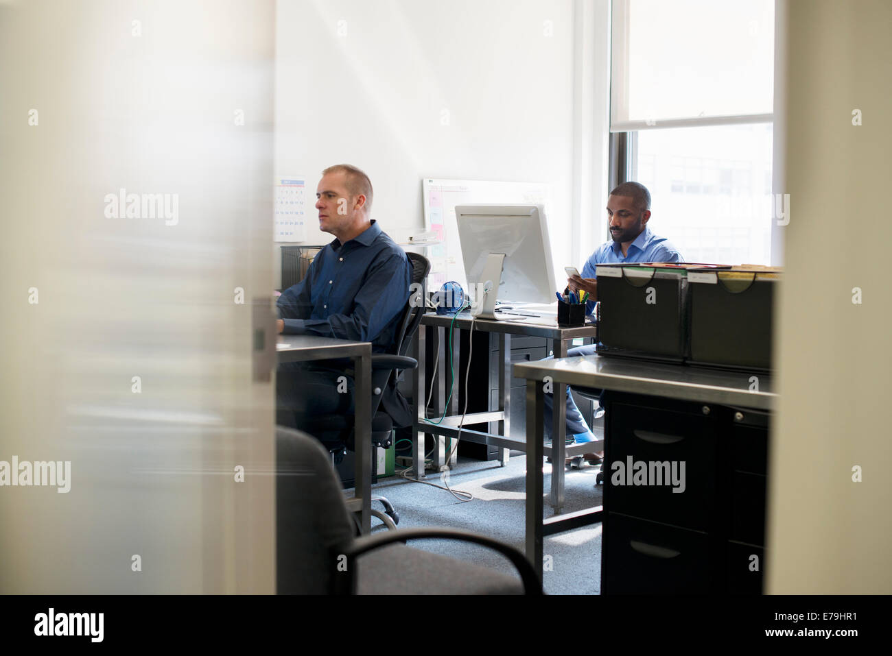 Zwei Männer in einem Büro arbeiten mit dem Computer. Stockfoto