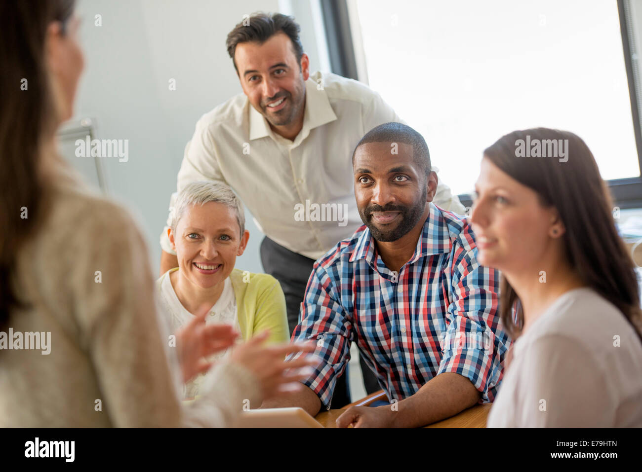 Fünf Menschen in einem Büro, zwei Männer und drei Frauen reden. Stockfoto