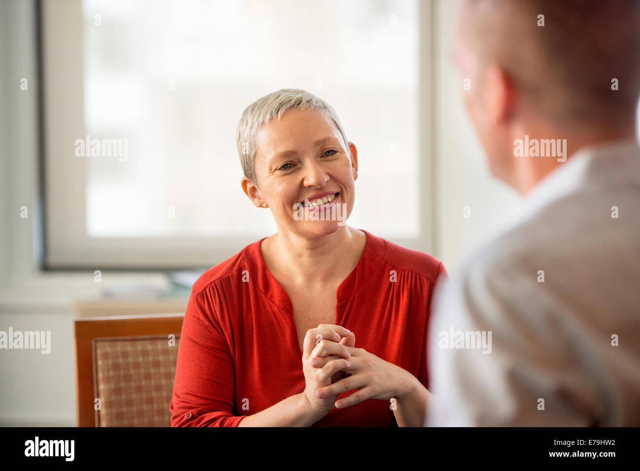 Eine Frau mit ihren Händen umklammert ein Mann lächelte. Stockfoto