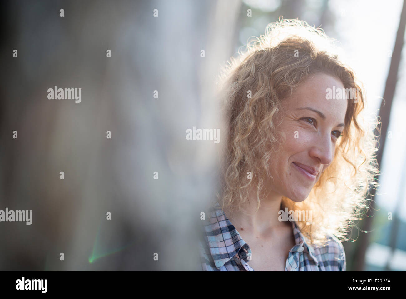 Eine Frau, im Schatten der Bäume an einem See. Stockfoto