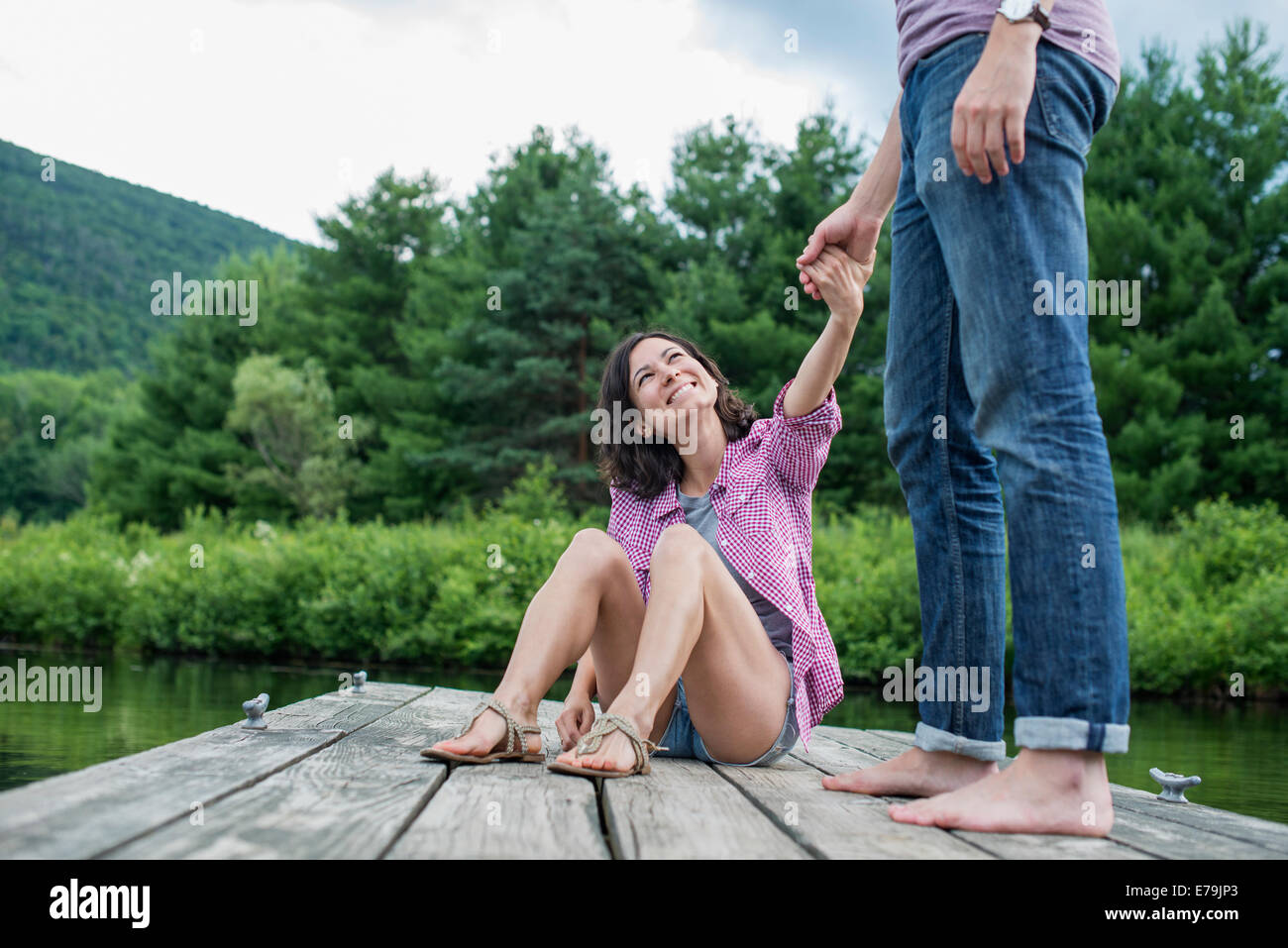 Ein paar auf einem hölzernen Steg an einem See. Stockfoto