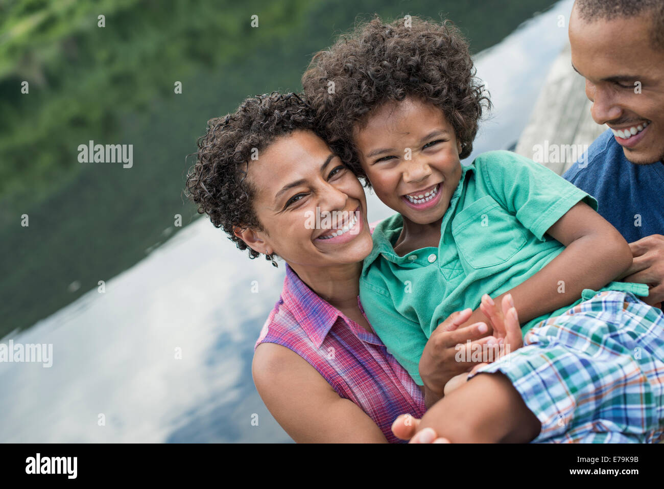 Eine Familie, Eltern und ein kleiner Junge, an einem See im Sommer. Stockfoto