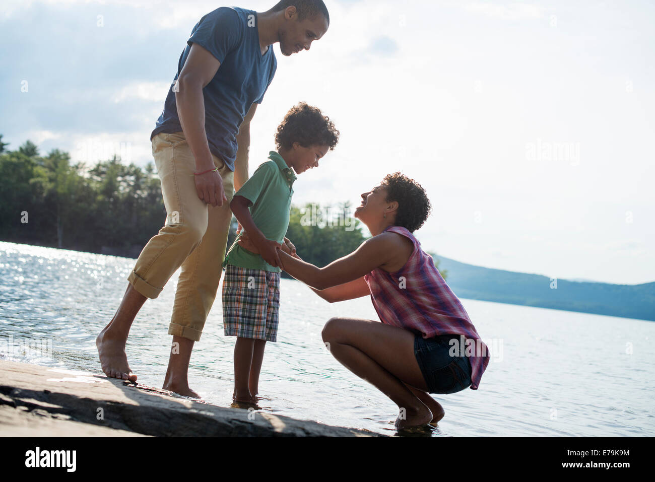 Eine Familie, Eltern und Sohn an einem See im Sommer. Stockfoto