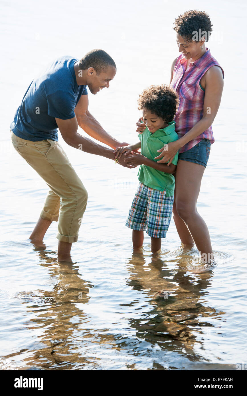 Familie, Mutter, Vater und Sohn spielen am Ufer eines Sees. Stockfoto