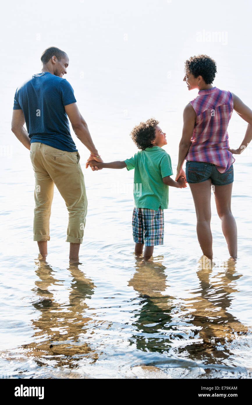Familie, Mutter, Vater und Sohn spielen am Ufer eines Sees. Stockfoto