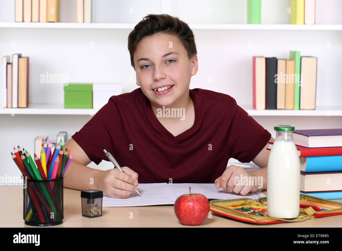 Junge, die Hausaufgaben in der Schule in seinem Schulheft Stockfoto