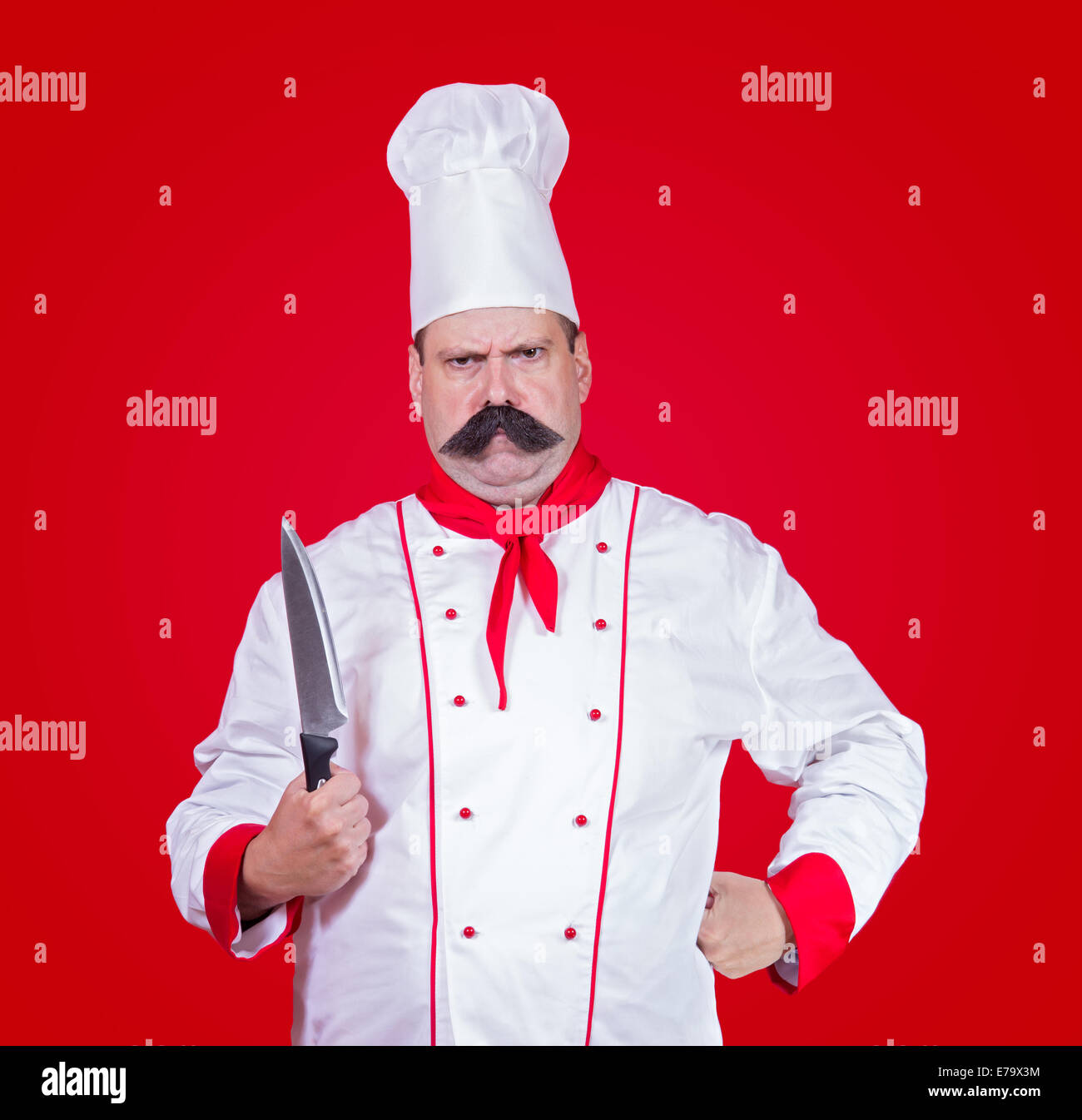 strenge Koch mit Messer auf rotem Grund Stockfoto