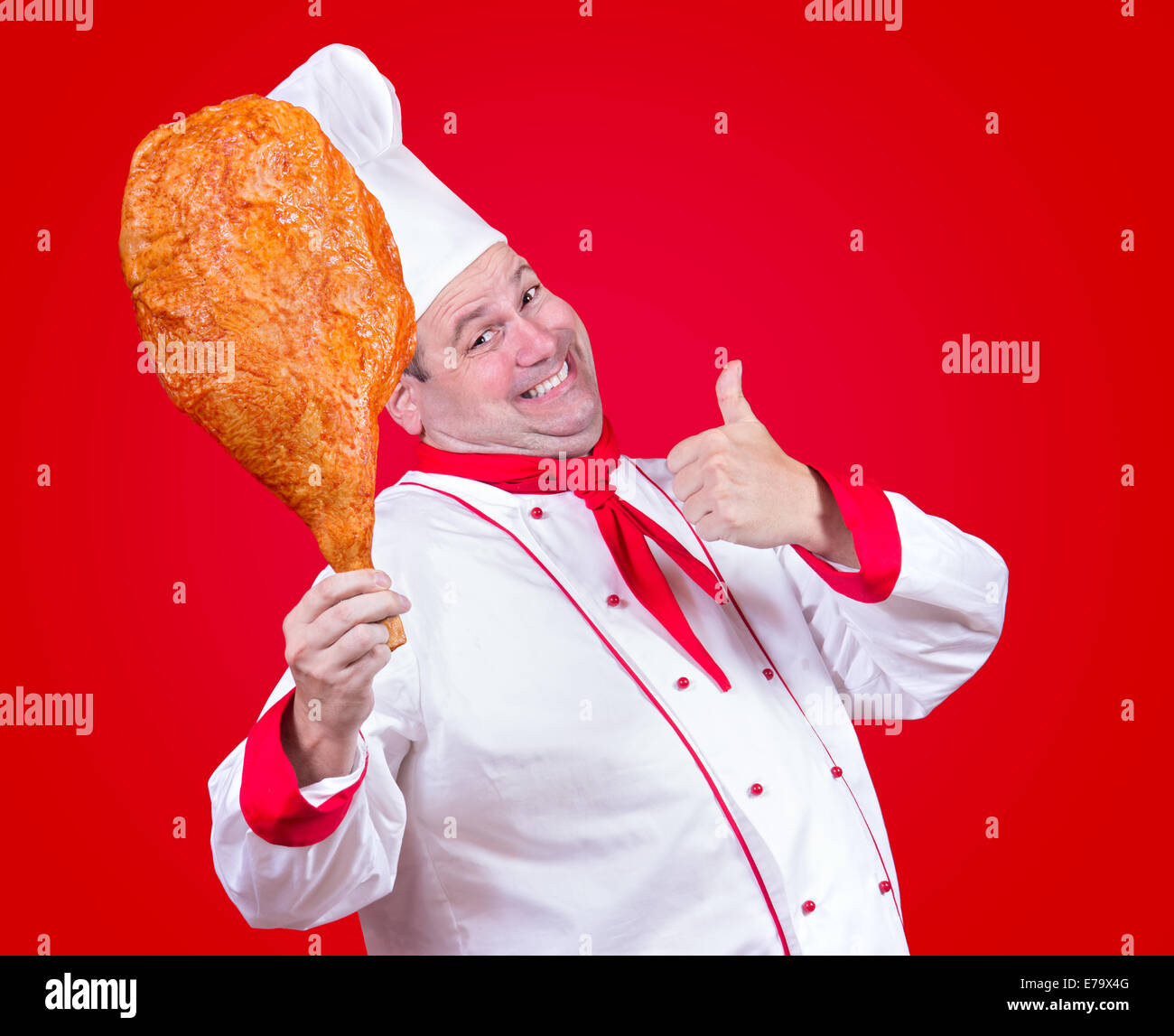 Koch hält in seiner Hand eine riesige Hühnerkeule Stockfoto