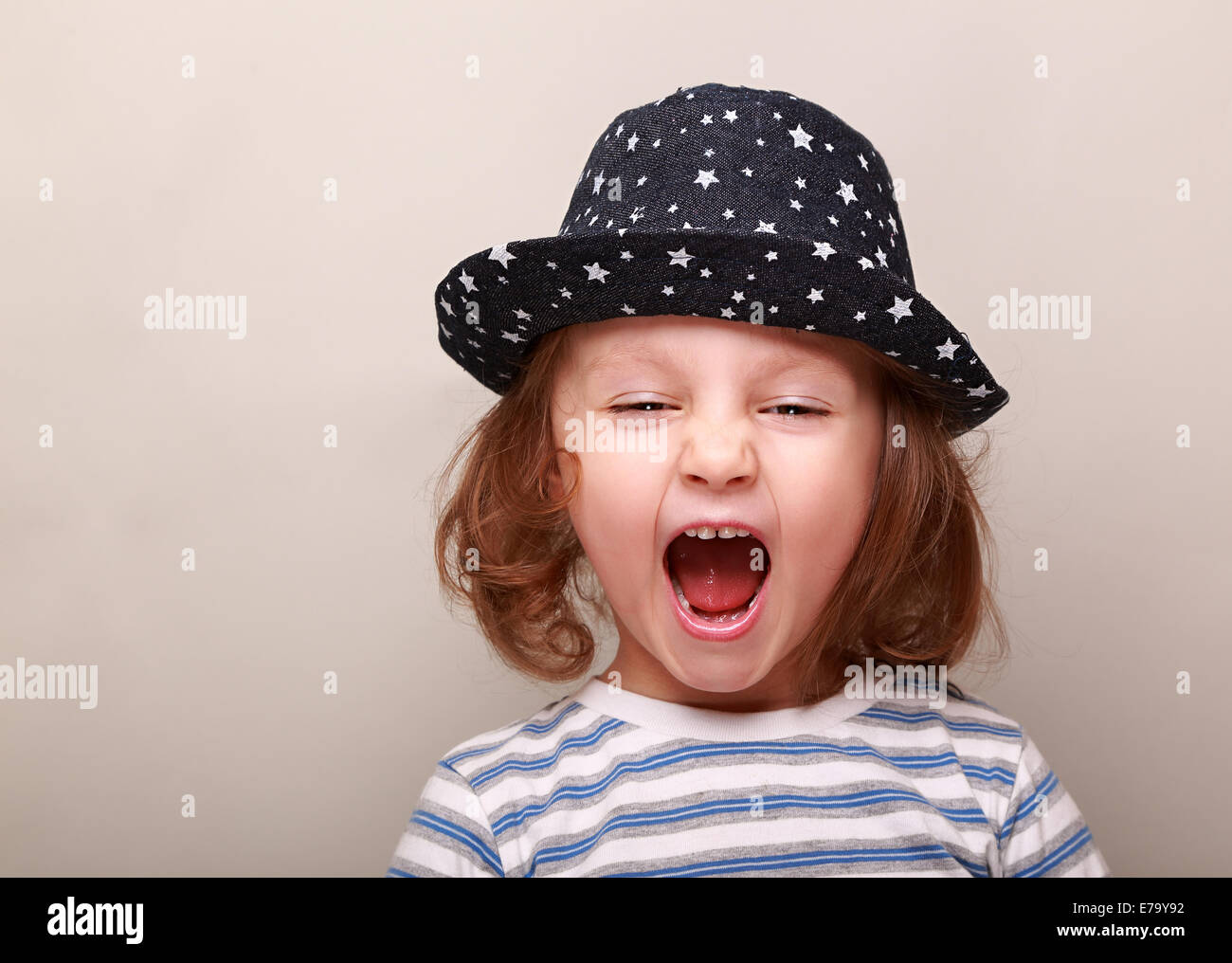Schreiende Kind Mädchen mit Hut mit offenem Mund auf leeren Raum Hintergrund Stockfoto