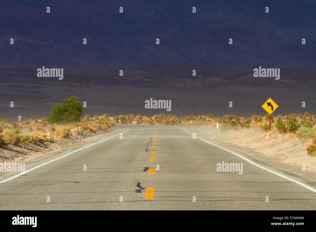 Sand weht über die Straße in der Nähe von Stovepipe Wells, Death Valley Nationalpark, Mojave-Wüste, Kalifornien, USA Stockfoto