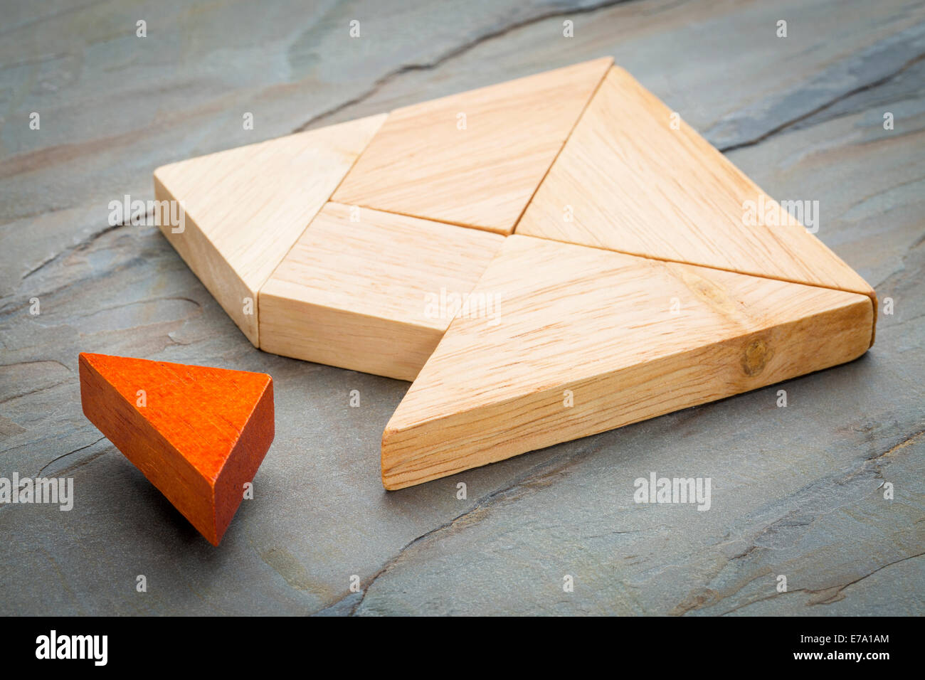 ein fehlendes Stück in einem Quadrat von Tangram-Formen, ein traditionelles chinesisches Puzzlespiel, Schiefer Felsen Hintergrund gebaut Stockfoto