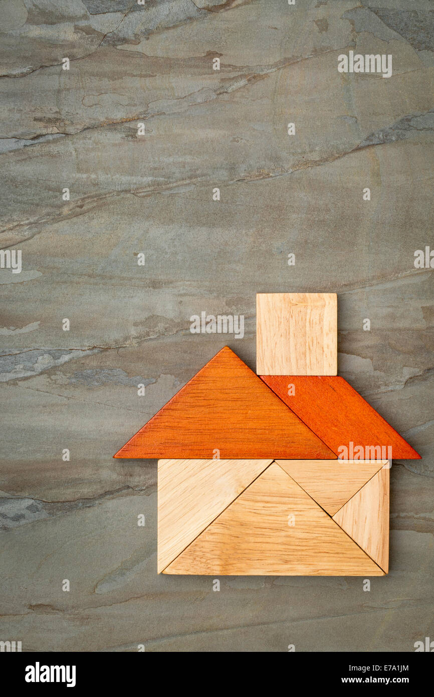 abstraktes Bild von einem Haus gebaut aus sieben Tangram Holzteile Schiefer Felsen Hintergrund, ein traditionelles chinesisches puzzle Stockfoto