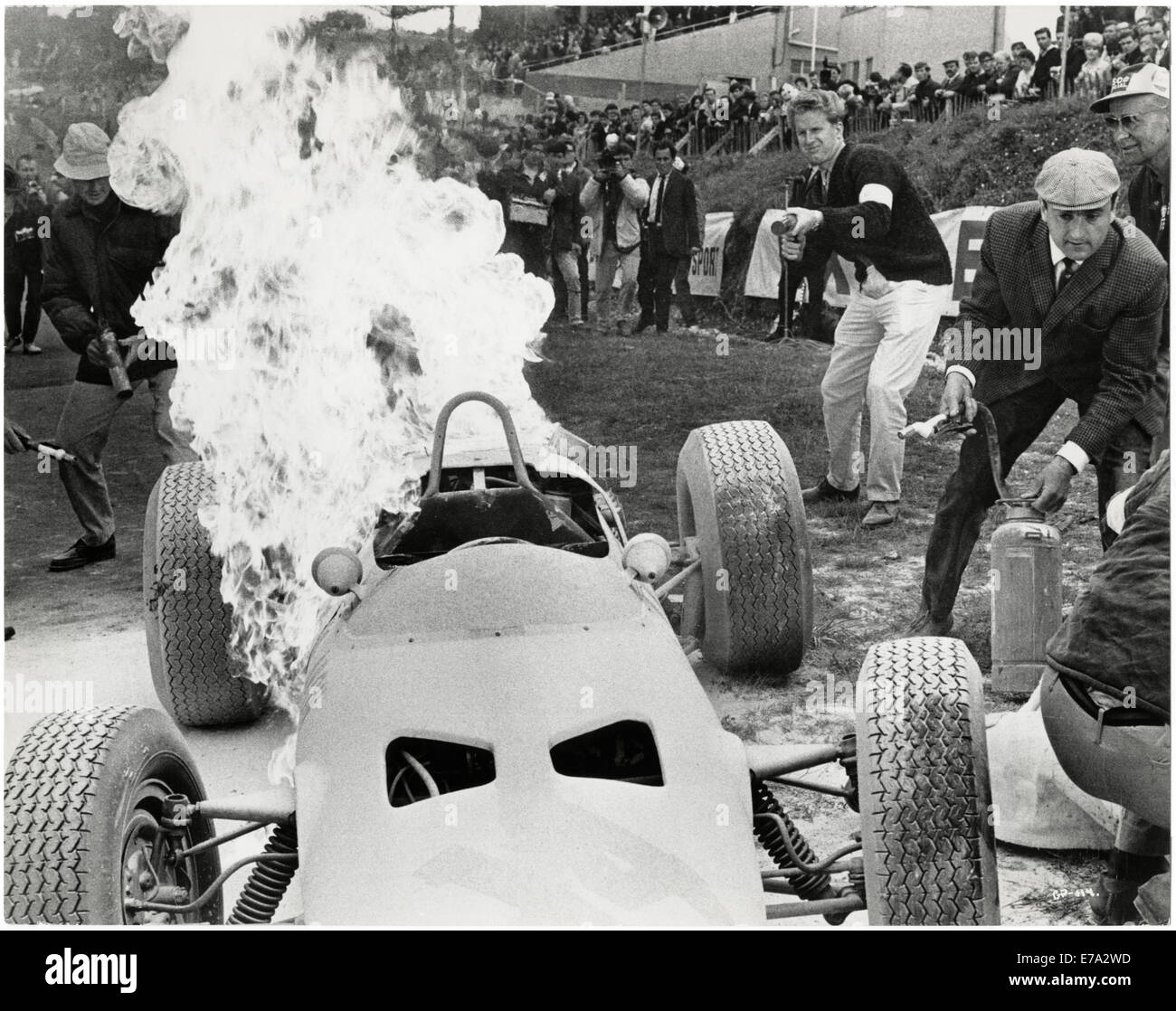 Techniker versuchen, die Flammen des brennenden Yamura Racer aus dem Film "Grand Prix", 1966 zu löschen Stockfoto